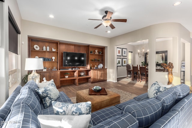 living room featuring hardwood / wood-style flooring and ceiling fan with notable chandelier