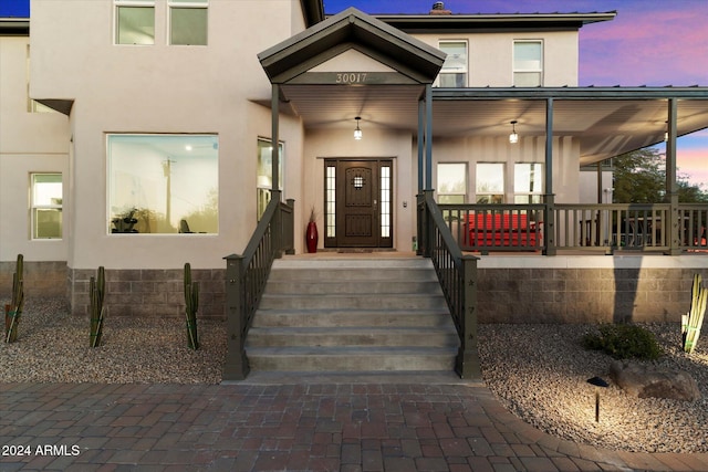 exterior entry at dusk featuring covered porch