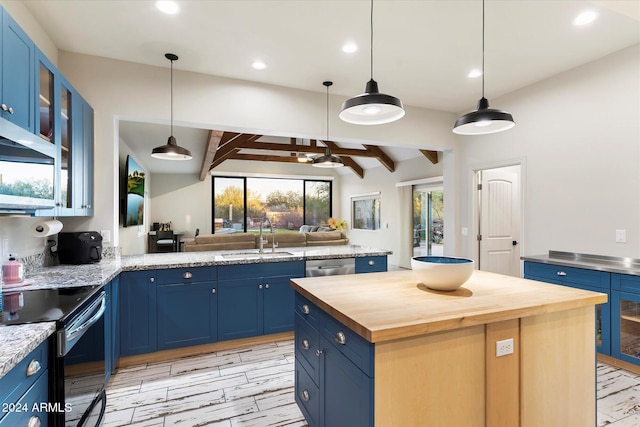 kitchen featuring blue cabinetry, decorative light fixtures, a kitchen island, and sink