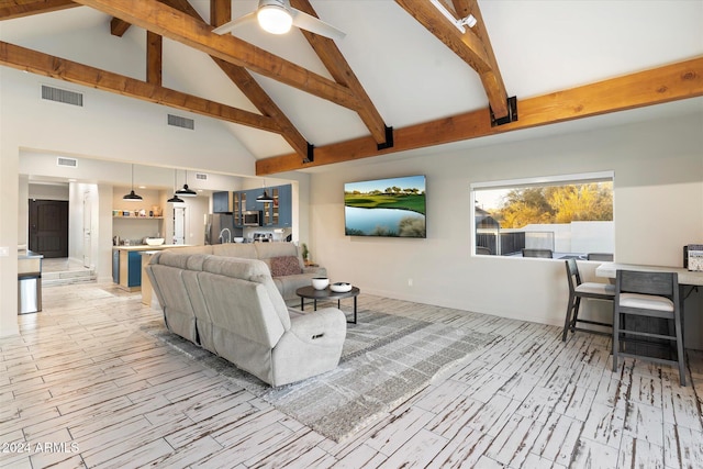 living room with ceiling fan, beamed ceiling, and high vaulted ceiling