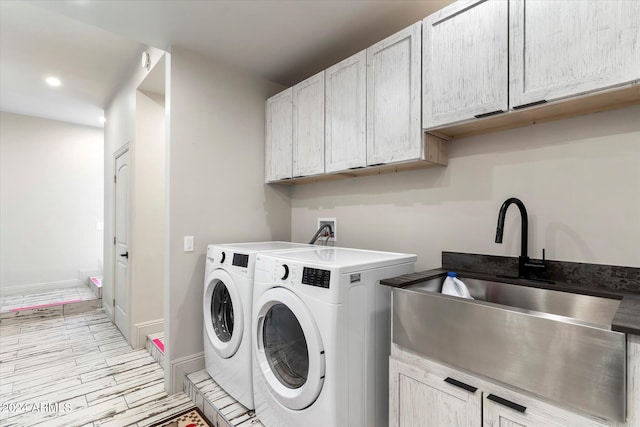 laundry room featuring washing machine and dryer, sink, and cabinets