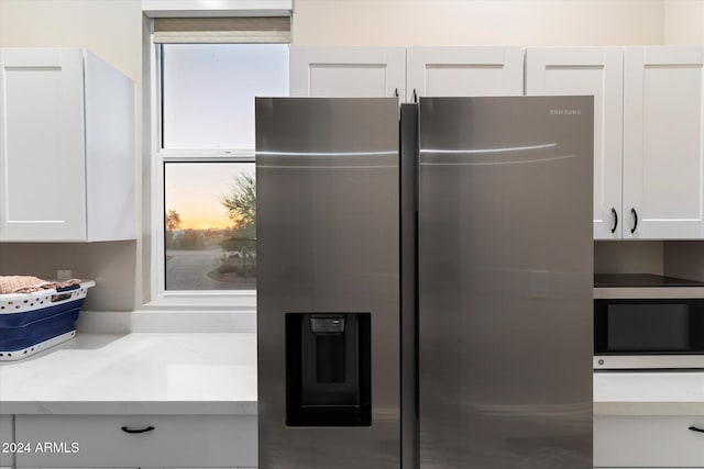 kitchen featuring appliances with stainless steel finishes, white cabinetry, and plenty of natural light