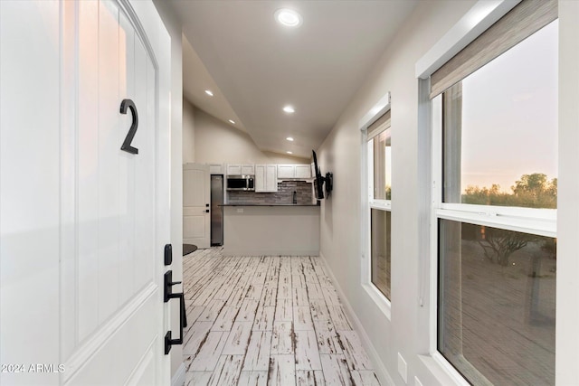 hallway with lofted ceiling