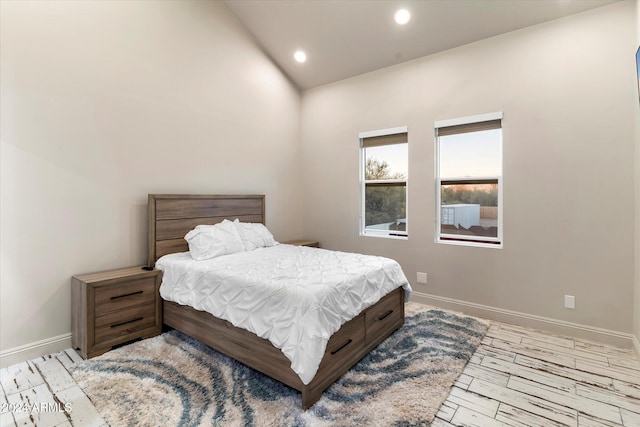 bedroom featuring light hardwood / wood-style flooring and lofted ceiling