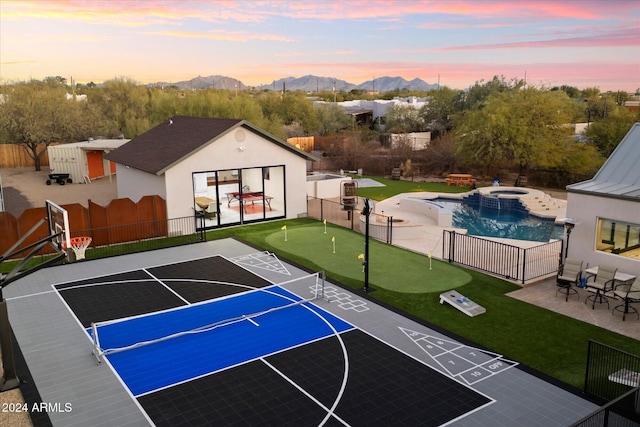 view of basketball court with a mountain view and a fenced in pool