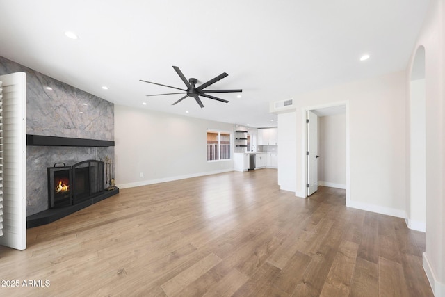 7535 W Kimberly Way, Glendale, AZ 85308 - unfurnished living room featuring ceiling fan, a large fireplace, wood finished floors, baseboards, and recessed lighting