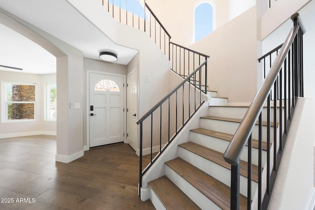 7535 W Kimberly Way, Glendale, AZ 85308 - foyer entrance featuring arched walkways, baseboards, wood finished floors, stairway, and a towering ceiling