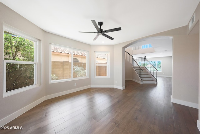 7535 W Kimberly Way, Glendale, AZ 85308 - spare room featuring arched walkways, stairway, dark wood-style flooring, and a ceiling fan