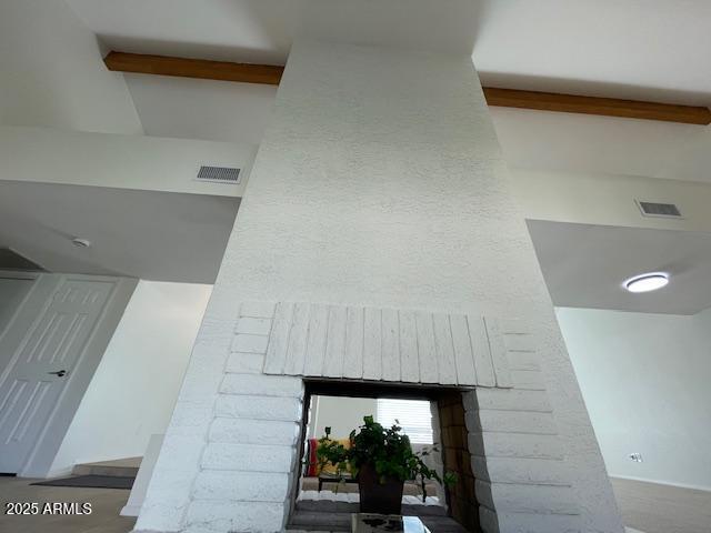 details with a brick fireplace and beamed ceiling