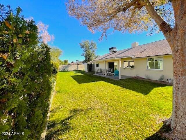 back of property featuring central AC, a patio area, and a lawn