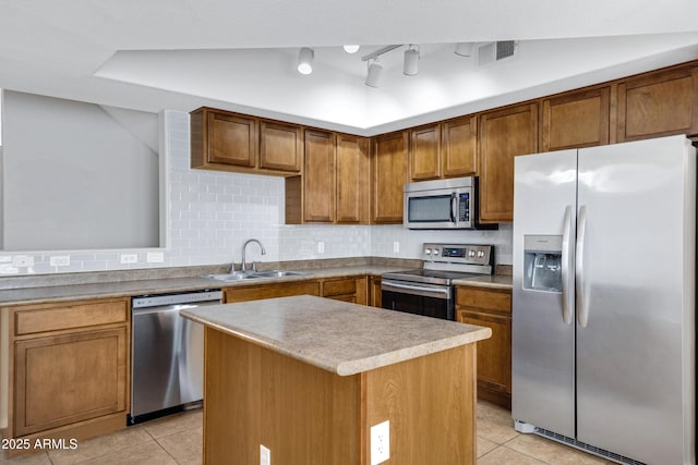 kitchen featuring light tile patterned flooring, a kitchen island, tasteful backsplash, sink, and stainless steel appliances