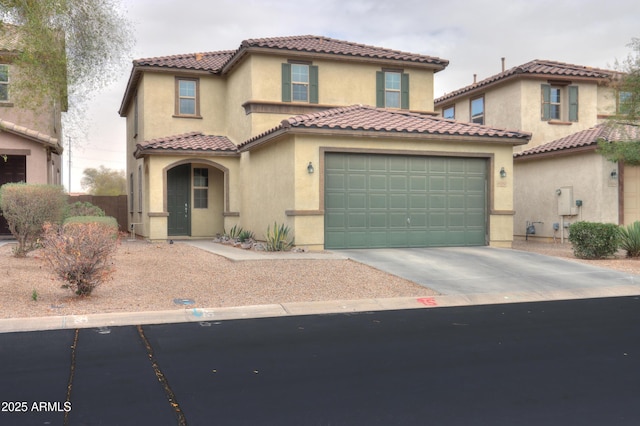 mediterranean / spanish home with stucco siding, driveway, an attached garage, and a tile roof