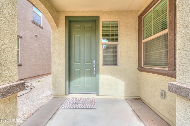 doorway to property featuring stucco siding