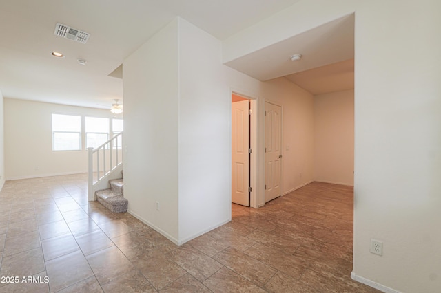 corridor with stairs, baseboards, and visible vents