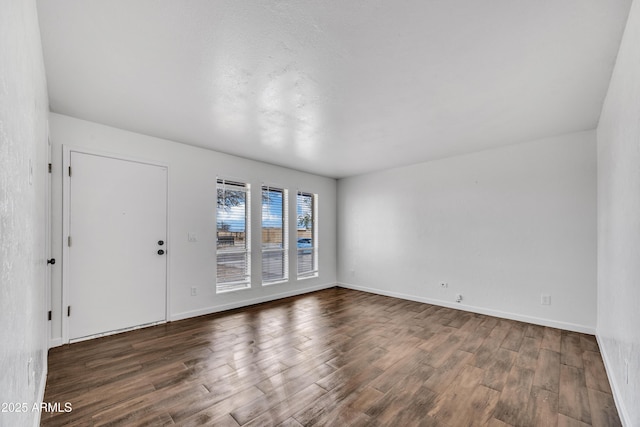 unfurnished room with wood finished floors and baseboards