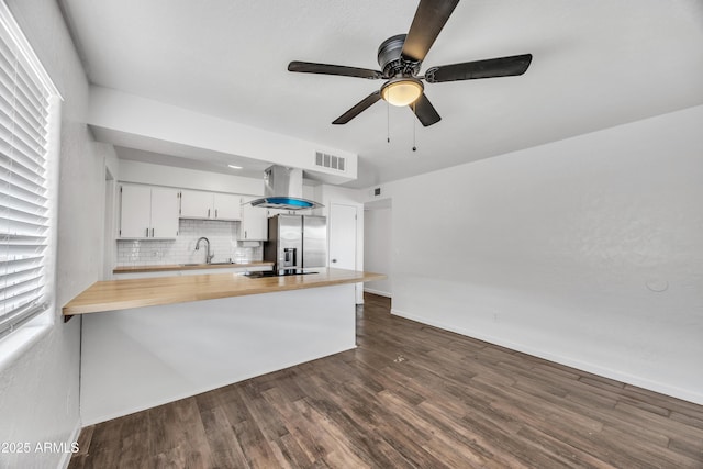 kitchen featuring a sink, stainless steel fridge, wall chimney exhaust hood, ceiling fan, and dark wood-style flooring