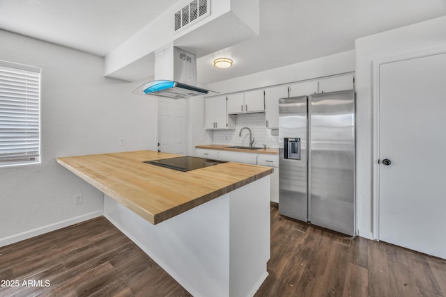 kitchen with visible vents, a sink, black electric cooktop, stainless steel fridge, and island range hood