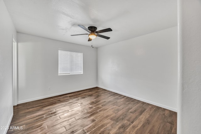 spare room with a ceiling fan, wood finished floors, and baseboards