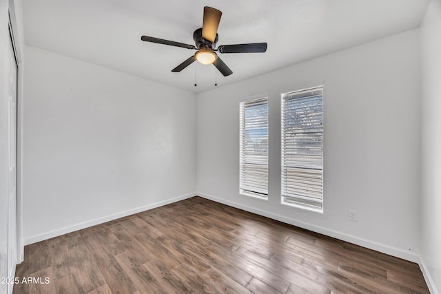 unfurnished room featuring baseboards, wood finished floors, and a ceiling fan