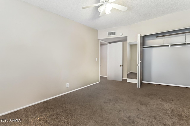 unfurnished bedroom featuring ceiling fan, dark carpet, a textured ceiling, and a closet