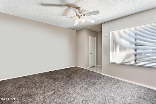 empty room with ceiling fan, light colored carpet, and a textured ceiling