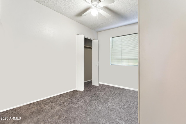 unfurnished bedroom featuring dark colored carpet, ceiling fan, and a textured ceiling