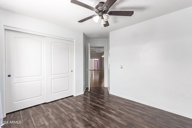 unfurnished bedroom featuring ceiling fan, dark hardwood / wood-style flooring, and a closet