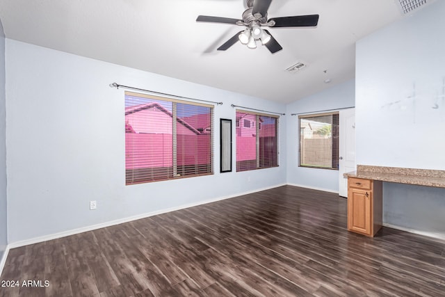 unfurnished living room featuring lofted ceiling, ceiling fan, built in desk, and dark wood-type flooring