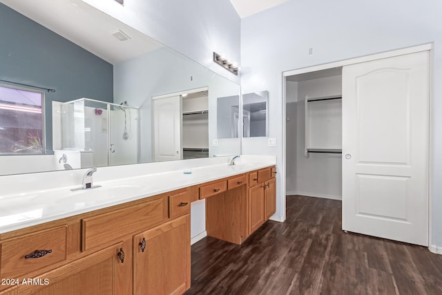 bathroom with hardwood / wood-style floors, vanity, and a shower with door