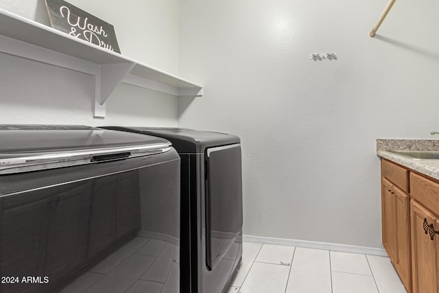 laundry area with washer and clothes dryer, light tile patterned floors, and sink