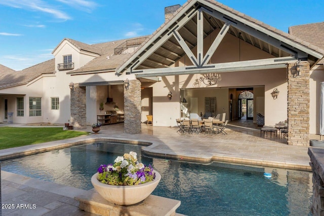 back of house with an outdoor kitchen and a patio area