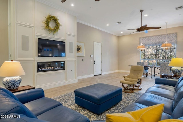 living room with ceiling fan, ornamental molding, and light hardwood / wood-style floors