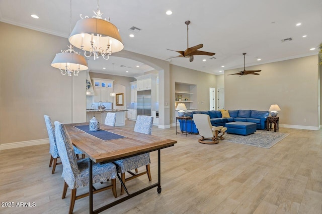 dining space featuring crown molding, ceiling fan with notable chandelier, built in features, and light hardwood / wood-style floors