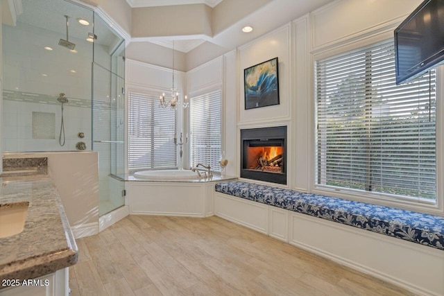 bathroom featuring hardwood / wood-style flooring, shower with separate bathtub, vanity, and an inviting chandelier