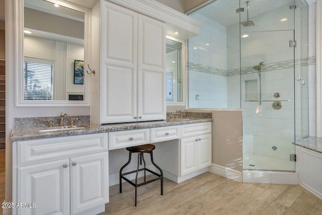 bathroom featuring vanity and a shower with door