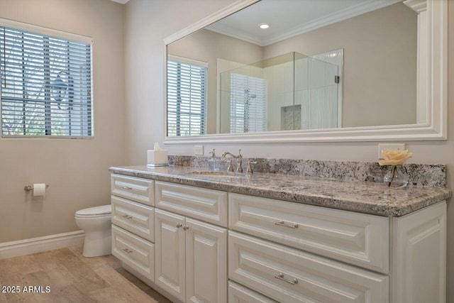 bathroom with a shower with shower door, wood-type flooring, vanity, ornamental molding, and toilet