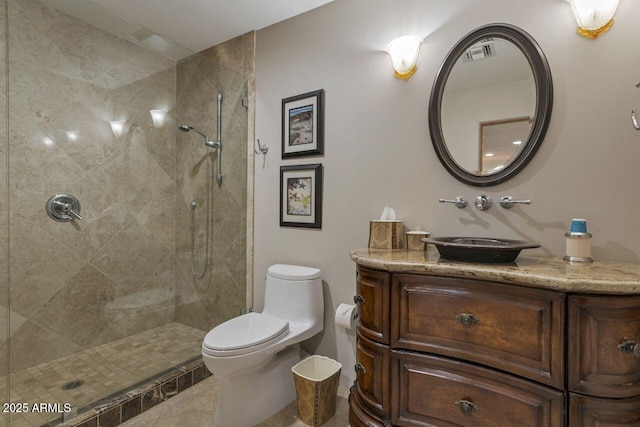 bathroom featuring vanity, toilet, tile patterned flooring, and a tile shower