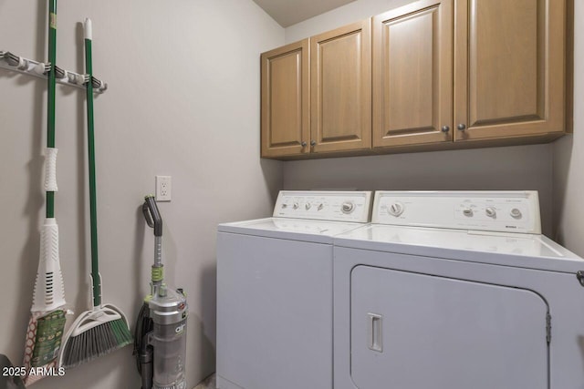 clothes washing area with cabinets and washing machine and dryer