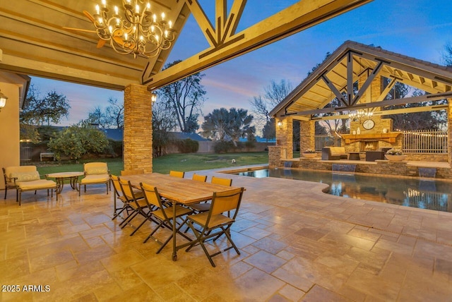 patio terrace at dusk with an outdoor stone fireplace