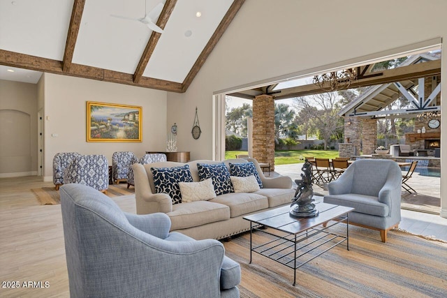 living room with ceiling fan, beam ceiling, light hardwood / wood-style floors, and high vaulted ceiling