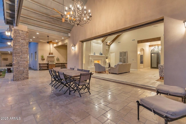 dining room with ornate columns, an inviting chandelier, and high vaulted ceiling