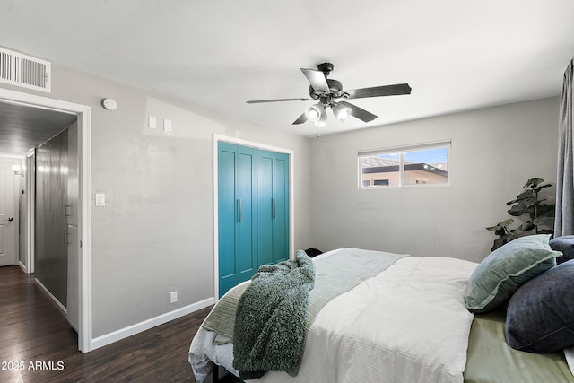 bedroom with a closet, dark wood-type flooring, baseboards, and a ceiling fan