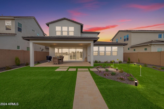 back house at dusk with a patio