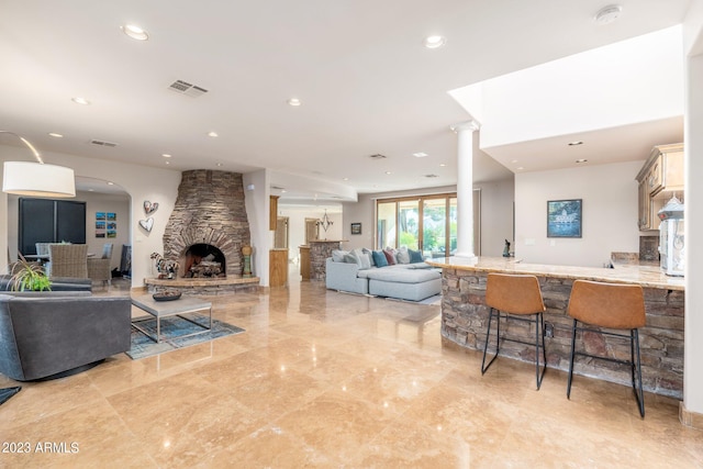 living room with decorative columns and a fireplace