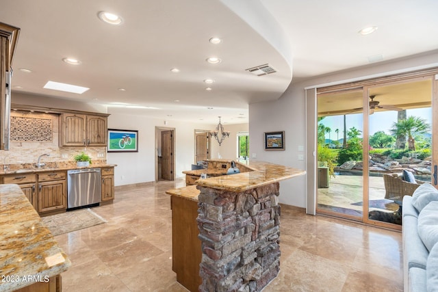 kitchen featuring tasteful backsplash, an island with sink, light stone counters, and stainless steel dishwasher