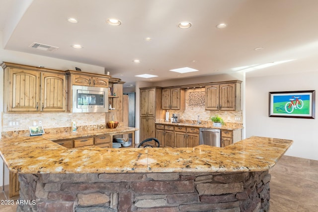 kitchen featuring stainless steel appliances, backsplash, and a center island