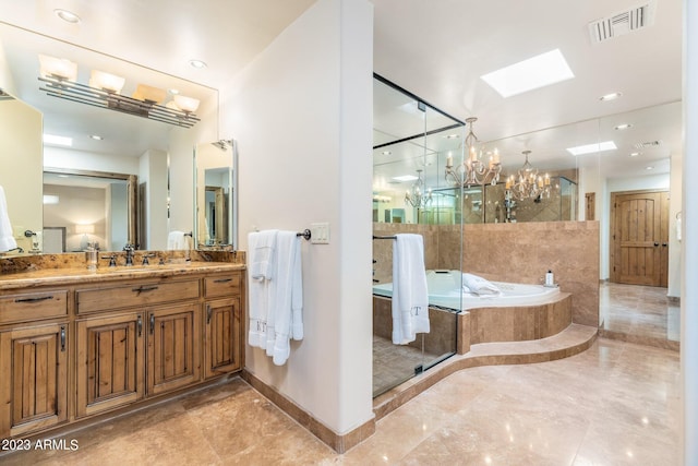 bathroom featuring a skylight, separate shower and tub, a chandelier, and vanity