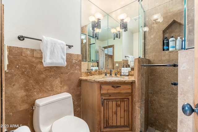 bathroom with walk in shower, tile walls, vanity, and toilet