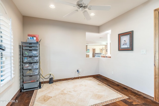 empty room featuring a healthy amount of sunlight, ceiling fan, and wood-type flooring