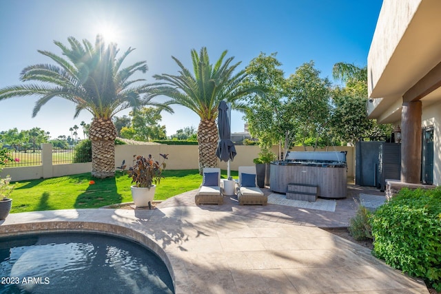 view of pool featuring a lawn, a patio area, and a hot tub